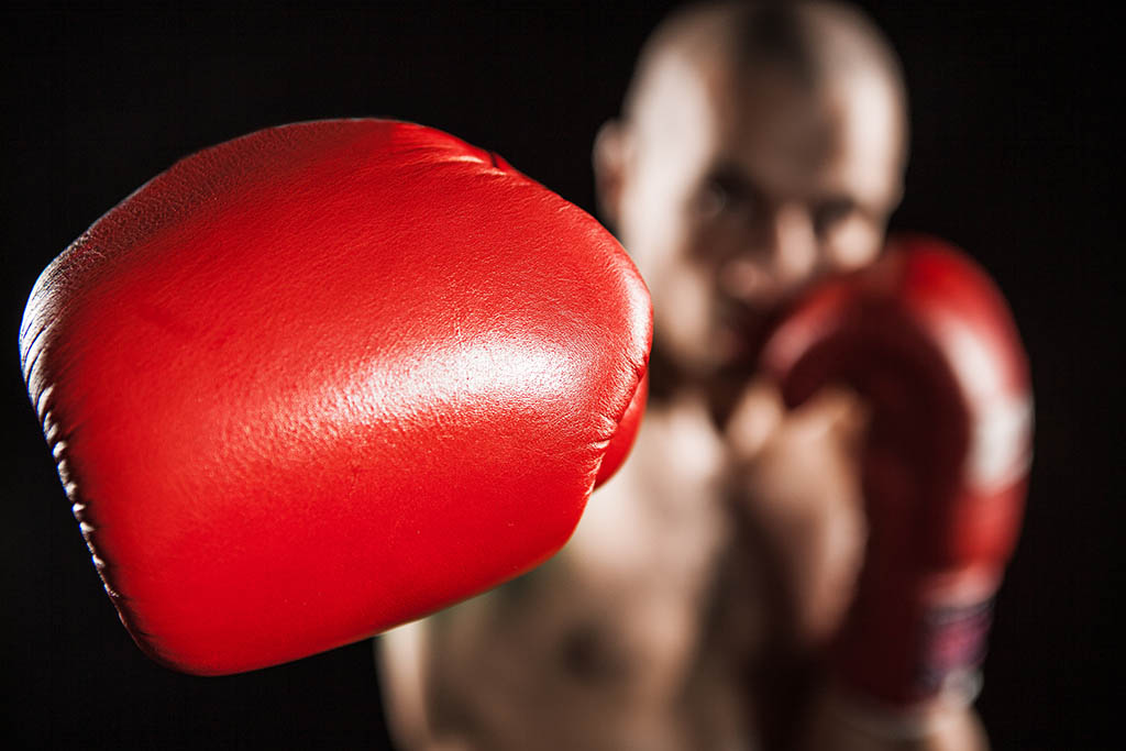 The young man kickboxing on black